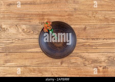 Empty flat plate of red clay over rustic wooden background .Top view. Flat lay. Stock Photo