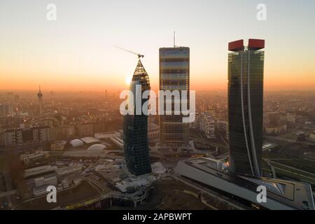 Milan city skyline at sunrise, aerial view. The new 3 skyscrapers (called the straight, the curved and the crooked) of Citylife district at dawn.