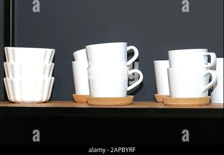 Retro white ceramic cups and bowls on kitchen shelf Stock Photo