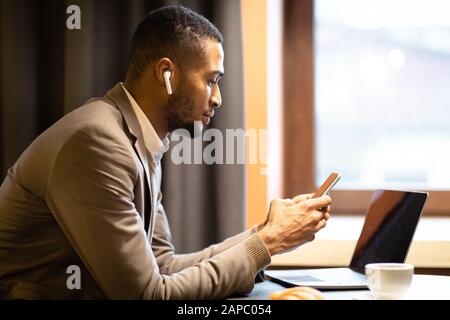 Portrait of black guy using cell phone and computer Stock Photo