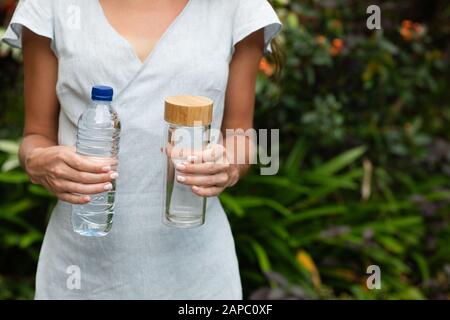 Choosing between plastic bottle and glass bottle. Zero waste concept. Green and conscious lifestyle concept. Stock Photo