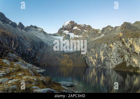 Mountain in Peru with lake, rocks and grass in the morning. Stock Photo