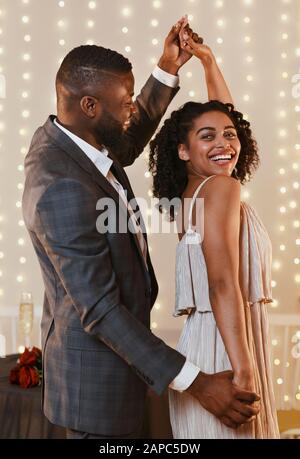 Portrait of beautiful black couple dancing in modern restaurant Stock Photo