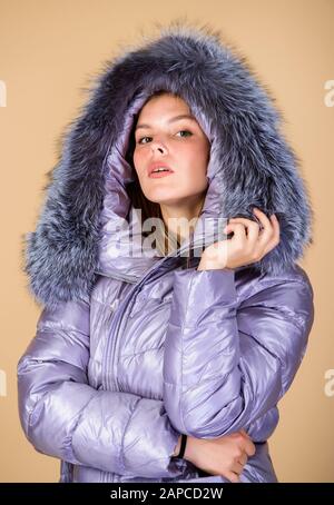 Faux fur. Warming up. Casual winter jacket slightly more stylish and have more comfort features such as larger hood fur trim on hood. Fashion girl winter clothes. Fashion trend. Fashion coat and hat. Stock Photo
