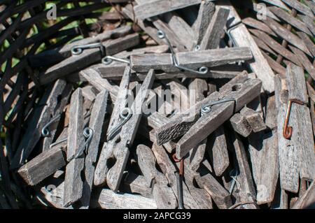Pile of weathered wooden laundry clamps closeup in reed basket Stock Photo
