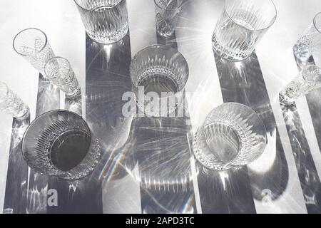 Trendy pattern made with glasses and shadows on gray white background. Sunlight through glass of water. Stock Photo