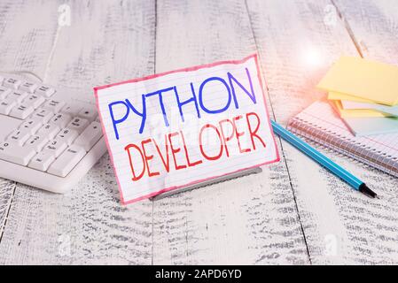 Writing note showing Python Developer. Business concept for responsible for writing serverside web application logic Notepaper on wire in between comp Stock Photo