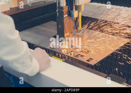 Laser cutting of metal sheet with sparks. Industry Stock Photo