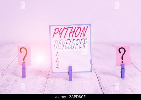 Writing note showing Python Developer. Business concept for responsible for writing serverside web application logic Crumbling sheet with paper clips Stock Photo