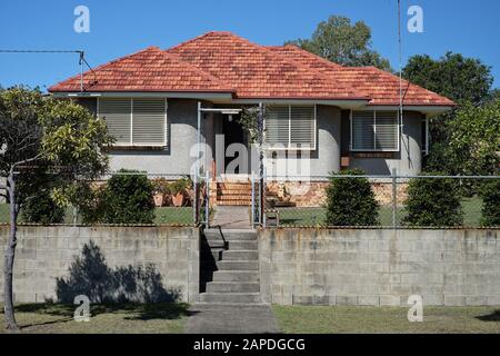 An almost, Art Deco style, Brick and Stucco house in Carina Brisbane with a cinder block retaining wall. Stock Photo