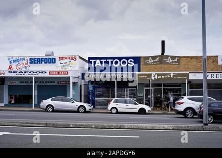 Seafood and Tattoo shops, Carina Heights commercial shopping street. Stock Photo