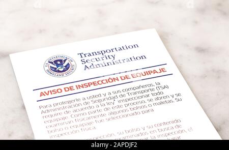 Notice of baggage inspection by TSA in Spanish. Shallow depth of field. Stock Photo