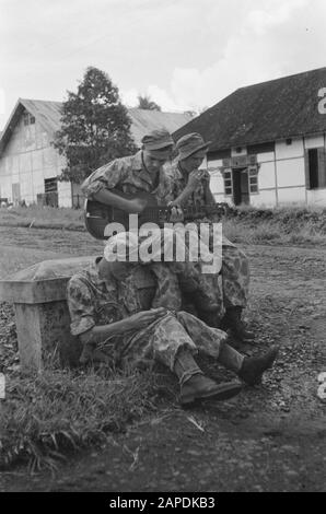 Coffee plantation 'de Koffiepot' at Ambarawa and “Zeeland in their doing and doing” Description: Ambarawa: The company De Koffiepot at Ambarawa has a heavy job in the security detachment on. Just a little time for a song and a cigarette. They are Leen Stokman from Wissekerke (with guitar), Oscar Verbiest from Koewacht and Janus Jacobse from Serooskerke. Date: 12 December 1947 Location: Indonesia, Dutch East Indies Stock Photo