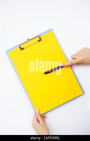 Blank Folder with Yellow Paper. Hand that Holding Folder and Handle on White Background. Copyspace. Place for Text Stock Photo