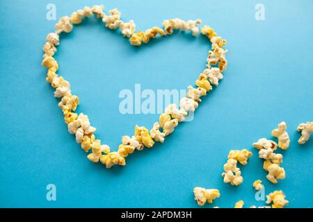 Food. Image of the Heart Forms from Popcorn. Delicious Popcorn on Blue Background. Cinema Stock Photo