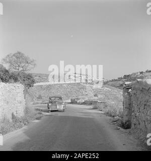 Israel 1948-1949: Canaan (Canaan) Description: Car on a mountain road with on the horizon a Tegart fort Annotation: Tegart forts (also called Taggart forts) are fortified concrete police stations that were built in strategic locations throughout Palestine in 1938, when this was a British mandate area. They are named after British policeman and engineer Sir Charles Tegart Date: 1948 Location: Israel, Safad Keywords: cars, mountains, police stations, defenses, roads Stock Photo
