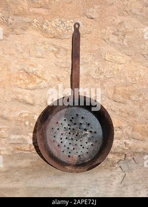 Vintage antique cooking pan colander with hand made perforated strainer holes in the botto. Includes clipping path if you wish to easily remove the ba Stock Photo