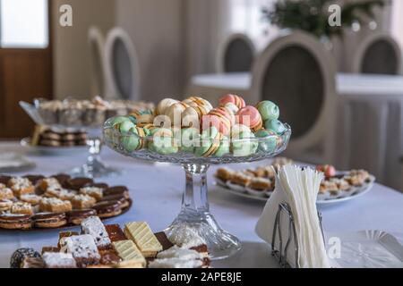 Beautiful dessert setting on a table with Macarons in a crystal glas bowl centerpiece Stock Photo
