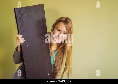 Caucasian woman using screwdriver for assembling furniture Stock Photo