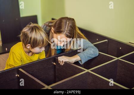 Mother and son assembling furniture. Boy helping his mom at home. Happy Family concept Stock Photo