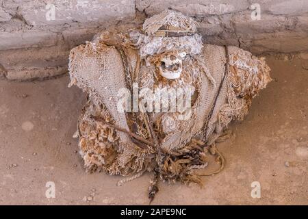 Overhead shot of a skull wrapped around with cloths leaned against a wall Stock Photo