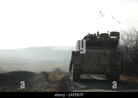 U.S. Soldiers of the 4th Squadron, 9th Cavalry Regiment, 2nd Armored Brigade Combat Team, 1st Cavalry Division, manuever a M3 Bradley Fighting Vehicle through live fire lanes during Combined Resolve XIII at the Grafenwoehr Training Area in Grafenwoehr, Germany, Jan. 16, 2020. Combined Resolve XIII is a Headquarters Department of the Army directed Multinational Unified Land Operation exercise with the U.S. Regionally Aligned Force Brigade in support of European Command (EUCOM) objectives. The purpose of the exercise is to prepare the 2nd Armored Brigade Combat Team, 1st Cavalry Division along w Stock Photo