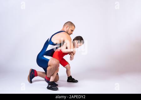 The concept of child power and martial arts training. Teaching children Greco-Roman wrestling. Boy and dad athletes in sportswear and wrestling equipm Stock Photo