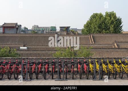 Xi'An, Shaanxi provice, China - Aug 8, 2018 : Red and yellow bicycles in a row on the city fortified wall Stock Photo