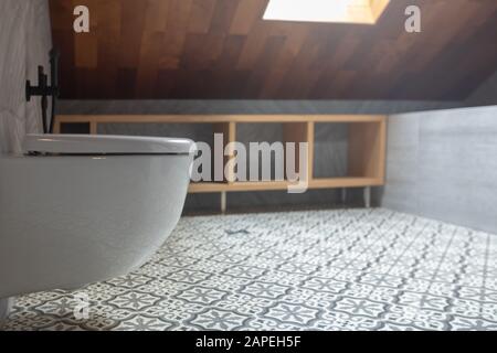 Modern white toilet bowl in bathroom with roof top window Stock Photo