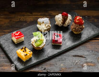 Selection of different dessert pastry sweet mini cakes and tartlets. Stock Photo