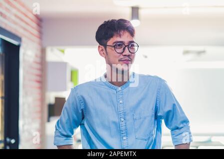 portrait of asian creative designer standing and smile in modern office Stock Photo