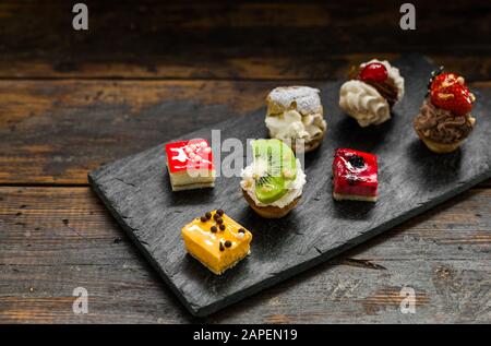 Selection of different dessert pastry sweet mini cakes and tartlets.