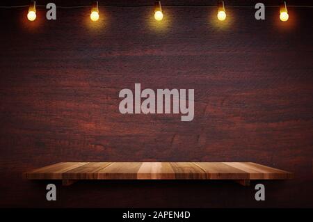 Empty brown plank wood shelf at black red wooden wall background with light bulbs string,Mockup for display or montage of product or design. Stock Photo