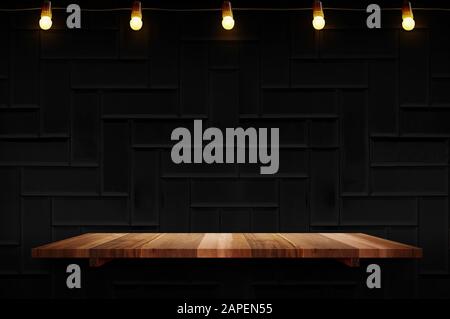 Empty brown plank wood shelf at black modern tile wall background with light bulbs string,Mockup for display or montage of product or design. Stock Photo