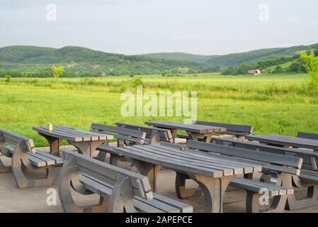 Benches and tables outdoors in a rustic landscape Stock Photo