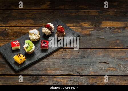Selection of different dessert pastry sweet mini cakes and tartlets. Stock Photo