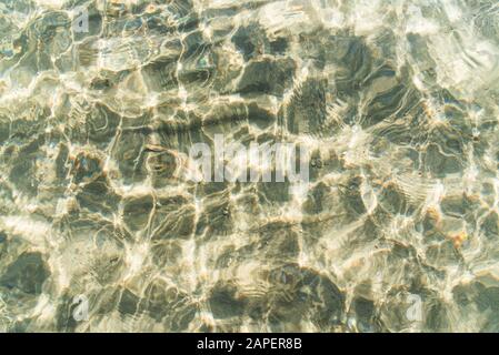 Transparent water surface and sand on the lake bottom. Stock Photo