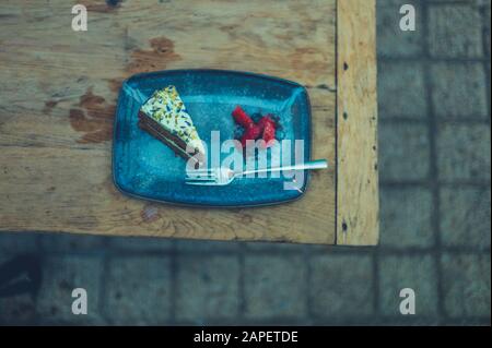 A cake with strawberries on a plate outdoors Stock Photo