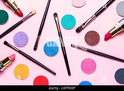 Different makeup brushes and  eye shadow on pastel pink background. Flat lay, top view. Stock Photo