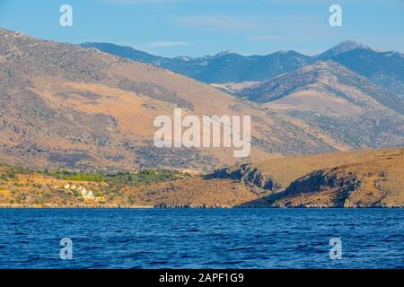 Greece. The hilly coast of the Gulf of Corinth. Summer day. Several cottages on the shore Stock Photo
