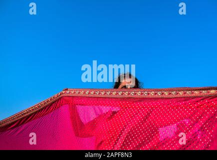 A woman is drying her saree by sunlight in a transits camp at Kolkata, India. Stock Photo