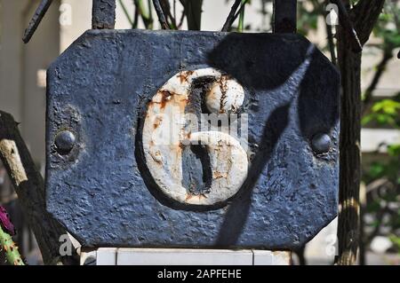 A house number plaque, showing the number six (6) Stock Photo