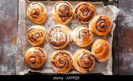 Top view sweet homemade cinnamon rolls with chocolate cream on a baking sheet Stock Photo