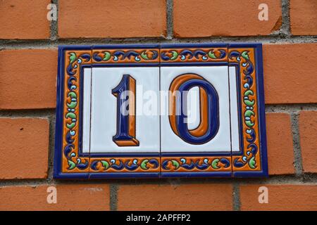 A house number plaque, showing the number ten (10) Stock Photo