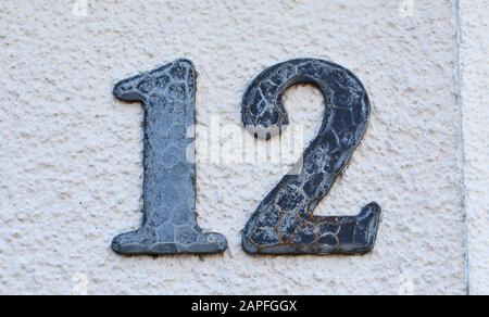 A house number plaque, showing the number twelve (12) Stock Photo