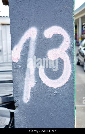 A house number plaque, showing the number thirteen (13) Stock Photo