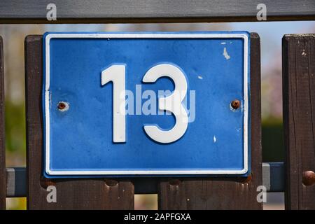 A house number plaque, showing the number thirteen (13) Stock Photo