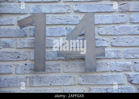 A house number plaque, showing the number fourteen (14) Stock Photo