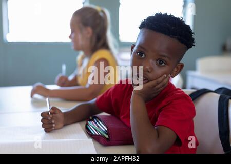 Schoolboy sitting at a desk in an elementary school classroom Stock Photo