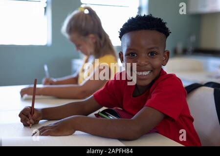 Schoolboy sitting at a desk in an elementary school classroom Stock Photo